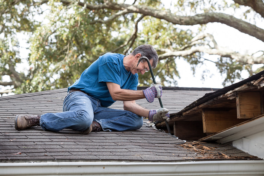 man fixing a damaged roof